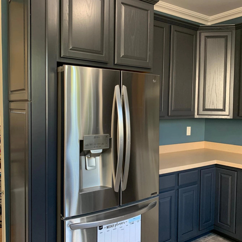 Platinum fridge with grey cabinets of a blue kitchen
