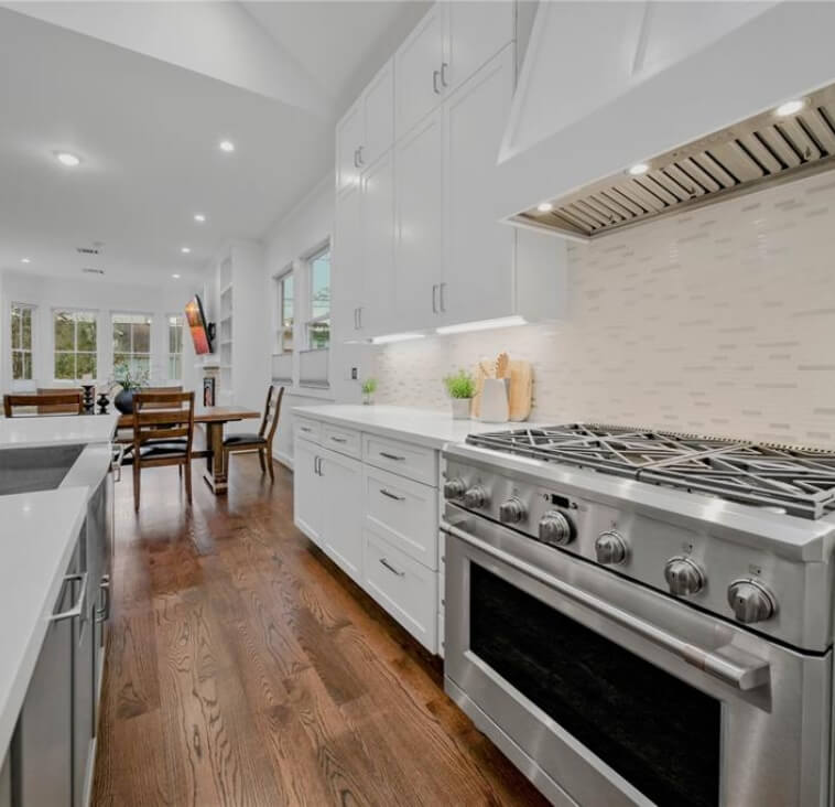 A modern kitchen featuring stainless steel appliances and white cabinetry.