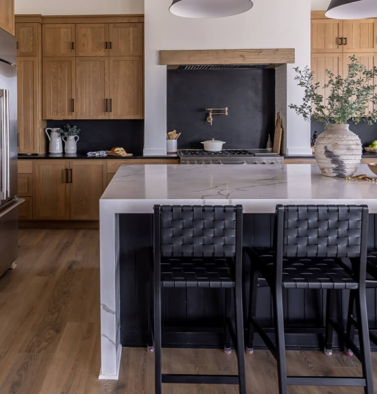 A stylish kitchen with black and wooden elements, showcasing a marble countertop.